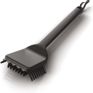 Ninja Brush for BBQ grill—cleaning made easy. Check out those flexible nylon bristles. And that sturdy handle? Perfect for getting into those hard-to-reach spots. Resting on a rustic wooden surface, it’s ready to tackle the mess from your last cookout.