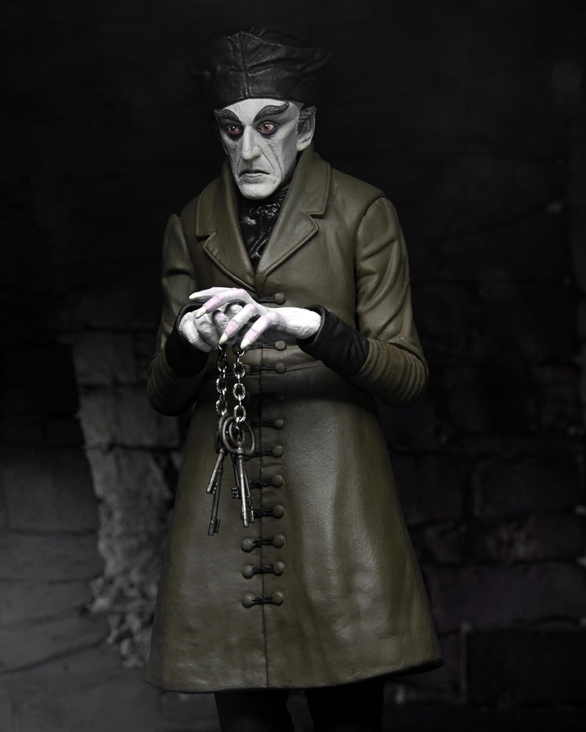 Close-up of the Nosferatu action figure—Count Orlok’s creepy vibe shines. Three heads to switch out, each one eerier than the last. Accessories galore: a sinister hat, old-school keys, and a quill. Perfect for collectors or anyone who loves a bit of gothic flair.