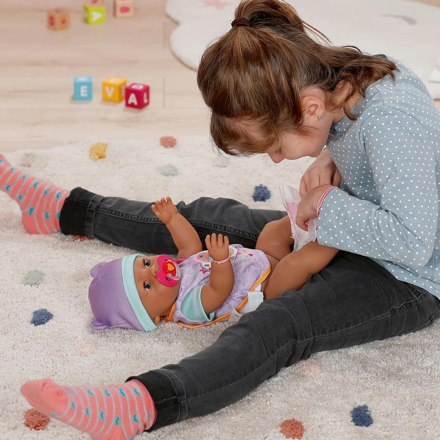 Eva, the adorable interactive doll—sitting on a vibrant play mat, her outfit a sweet rosy shade. Right there, her potty and feeding bowl waiting for fun, imagination sparking everywhere.